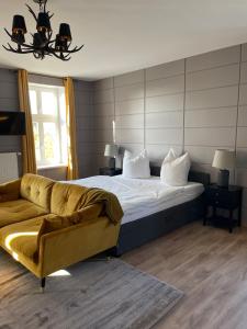 a bedroom with a bed and a couch at Gutshauszimmer Premium in Neu Gaarz