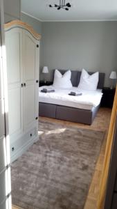 a bedroom with a bed and a white cabinet at Gutshauszimmer Premium in Neu Gaarz