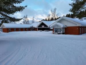 un bâtiment recouvert de neige avec une allée couverte de neige dans l'établissement Ruukin Kievari Hotelli Ravintola, à Juankoski