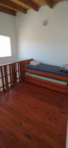1 dormitorio con 2 literas en una habitación con suelo de madera en Cabaña Nerviomotor en Córdoba