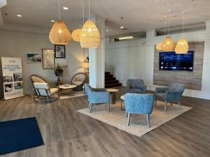 una sala de espera con sillas, mesas y TV en Grand Shores West en St Pete Beach