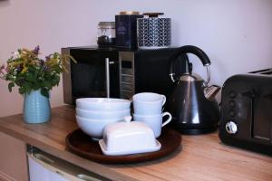 a counter with two cups and a microwave at Garden studio in Bradford on Avon in Bradford on Avon