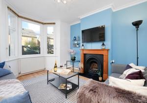 sala de estar con sofá y chimenea en Lovely 4 Bedroom London Home with Free Parking, Garden, WiFi By Roost Accommodation, en Kingston upon Thames