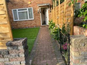 a brick walkway leading to a house with a fence at Specious Room in Northolt in Northolt