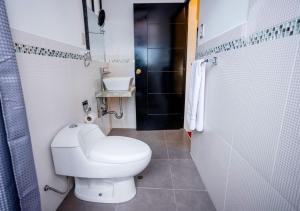 a bathroom with a white toilet and a shower at Hotel Kuska Home in Cusco