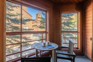 a table and chairs in a room with a large window at Aspen Creek 121 in Mammoth Lakes