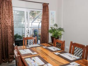 a dining room with a wooden table and a window at The Crescent Escape in Colwyn Bay