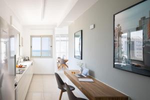 a kitchen with a wooden table and chairs in a room at Mate TLV PORT - By HOMY in Tel Aviv
