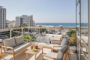 a balcony with chairs and a view of the ocean at Mate TLV PORT - By HOMY in Tel Aviv