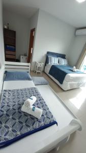 two beds sitting in a room with at Pousada Miguel Penha Sc in Penha