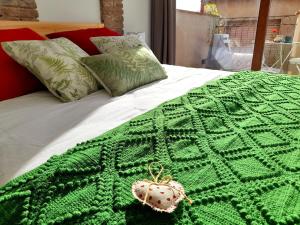 ein Bett mit einer grünen Häkeldecke darauf in der Unterkunft Cal Passió in Vimbodí + 44 Fotos