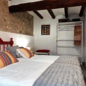 a bedroom with two beds and a red chair at Cal Passió in Vimbodí