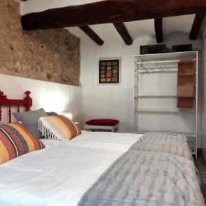 1 dormitorio con 2 camas y silla roja en Cal Passió, en Vimbodí