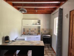 cocina con armarios blancos y encimera en Campito Refugio, en San José de Maipo