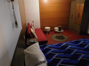 a bedroom with a bed and a couch and a table at MALA HIERBA in Cusco