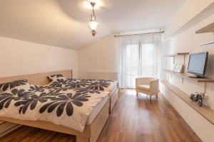 a bedroom with a bed and a television in it at Cheerful 4-bedroom & kids friendly home in Predeal