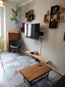 een woonkamer met een flatscreen-tv aan de muur bij plein coeur du quartier du Panier . Chaleureux T2. in Marseille