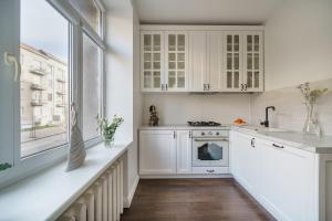 希奥利艾Nica Apartment的厨房配有白色橱柜和大窗户 更多12张照片