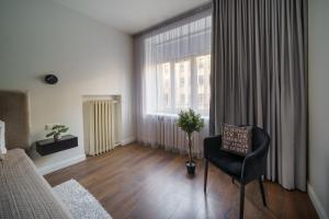 希奥利艾Nica Apartment的一间卧室，里面有一张床、一把椅子和一扇大窗户。