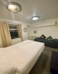 1 dormitorio con 1 cama blanca grande y 1 sofá en Lower ground Bell street, en Londres