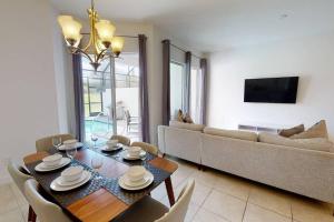 uma sala de estar com uma mesa e um sofá em Beautiful townhouse with pool close to Disney em Davenport