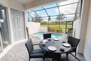 a patio with a table and chairs and a pool at Beautiful townhouse with pool close to Disney in Davenport
