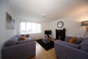 a living room with two couches and a fireplace at Belmont Budget Apartment in Stockton-on-Tees