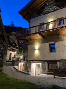 a large stone building with a balcony on it at Romantica camera in Valtournenche