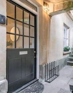una puerta negra en el lateral de un edificio en St Marg’s Hideaway; Grade II listed luxury apartment in the heart of Cheltenham - gateway to the Cotswolds! Sleeps 4 - outdoor seating and free private parking!, en Cheltenham