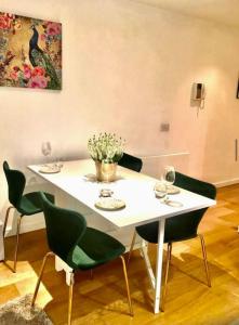 una mesa blanca con sillas y una pintura en la pared en Gorgeous apartment with free parking & breakfast near city centre & midday checkout, en Bristol