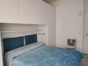 a bedroom with a bed with a blue comforter at da Rosa in Finale Ligure