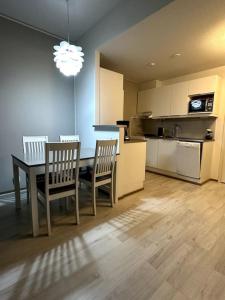 a kitchen with a table and two chairs and a kitchen with a counter at Quality Apt in the City Center For 5 - BRAND NEW in Rovaniemi +1 photo
