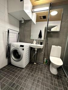 a small bathroom with a washing machine and a toilet at Quality Apt in the City Center For 5 - BRAND NEW in Rovaniemi