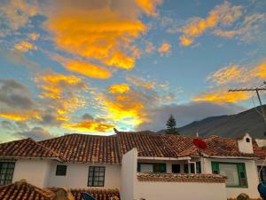 a house with a cloudy sky in the background at Casa Villa de Leyva in Villa de Leyva