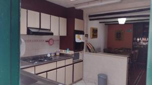 uma cozinha com armários brancos e um forno com placa de fogão em Casa Villa de Leyva em Villa de Leyva