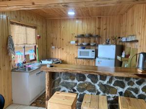 una cocina con encimera de piedra en una cabaña en Cabañas La Chasconita, en Constitución