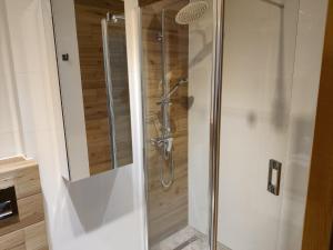 a shower with a glass door in a bathroom at Apartament De Lux LIDIA in Karpacz