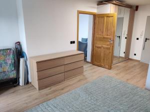 a bedroom with a wooden dresser and a door at Apartament De Lux LIDIA in Karpacz