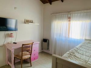 a bedroom with a desk and a bed and a tv at LOS SAUCES CHASCOMUS in Chascomús