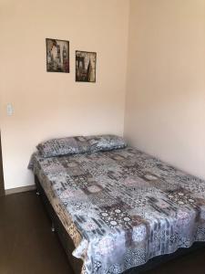 a bed in a room with two pictures on the wall at Casa do Porto - a 600m do Mar e da Lagoa in Florianópolis