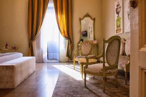 a living room with a couch, chair and a window at B&B Palazzo Cerami in Catania