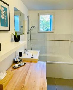 ein Badezimmer mit einem Waschbecken, einer Dusche und einer Badewanne in der Unterkunft Charmante petite maison flamande in Bondues