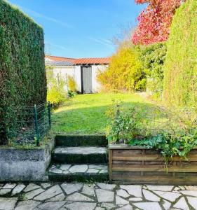a garden with some stairs in the grass at Charmante petite maison flamande in Bondues