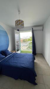 a bedroom with a blue bed and a large window at Nawalie in Pointe-à-Pitre