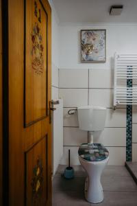 a bathroom with a toilet and a wooden door at Kellerstöckl Rosalie in Rechnitz