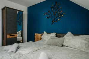 um quarto com uma cama com uma parede azul em Kellerstöckl Rosalie em Rechnitz