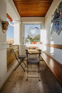 einen Tisch und Stühle in einem Zimmer mit einem Herzfenster in der Unterkunft Kellerstöckl Rosalie in Rechnitz