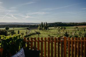 a wooden fence with a view of a field at Kellerstöckl Rosalie in Rechnitz