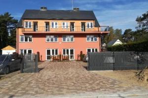 a large house with a fence in front of it at Apartments, Niechorze in Niechorze