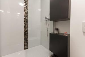 卢布尔雅那Gorgeous central flat with garage的厨房设有白色的墙壁和黑色的橱柜。 更多43张照片